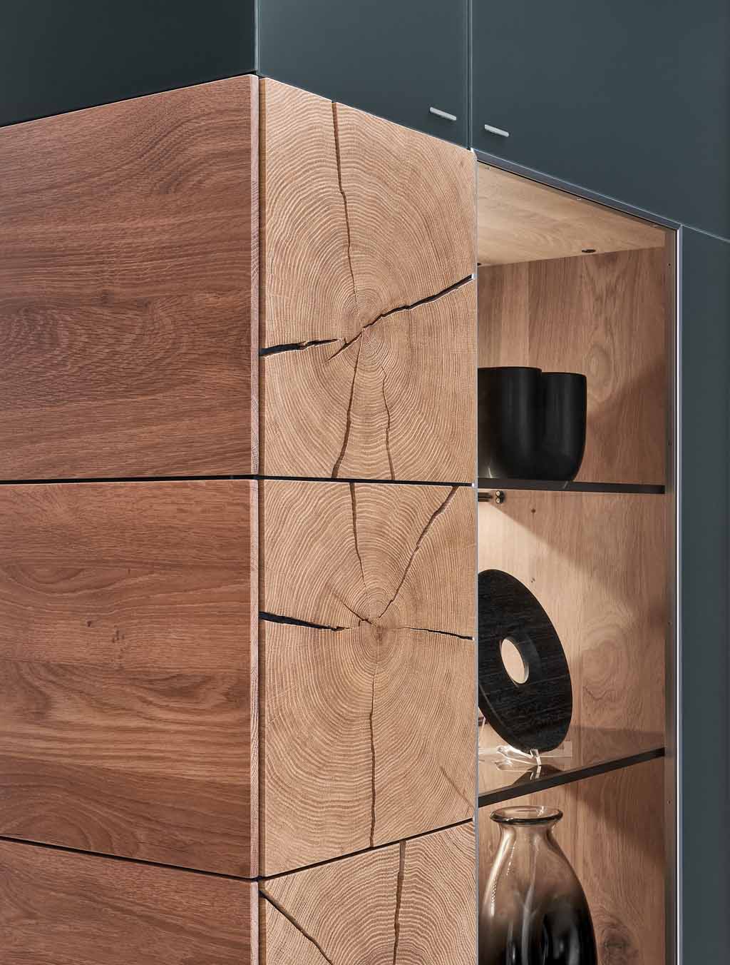 Nahaufnahme einer Massivholz Vitrine mit Hirnholz Akzent und schwarze Dekoration