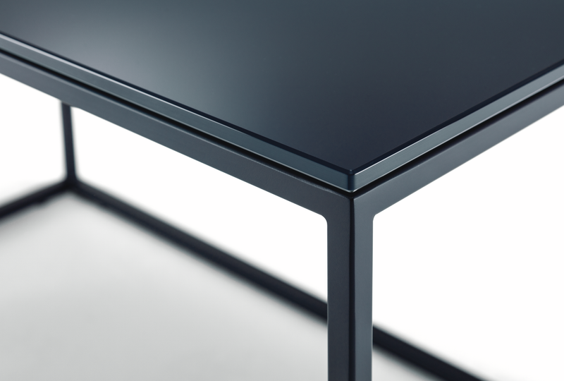 Detailansicht eines modernen Couchtisches mit schwarzer Metalloberfläche und stabilen, geraden Linien.