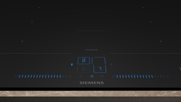 Detailansicht der Bedienelemente des Siemens studioLine Induktionskochfelds EX67BNYV6E. Die blauen Digitalanzeigen zeigen die Stufen '8' und '7' an.