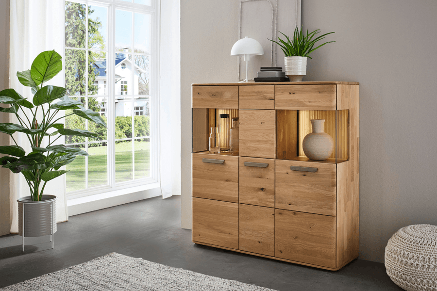 Massivholz Highboard mit Designer Griffen und Vitrinenfächern, die beleuchtet sind.
