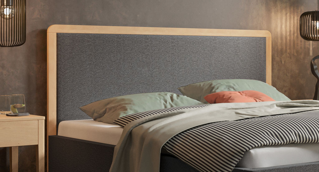 Nahaufnahme des grau bezogenen Polsterkopfteils mit massiver Holzeinfassung aus heller, geölter Eiche in einem Schlafzimmer (KI-generiert)