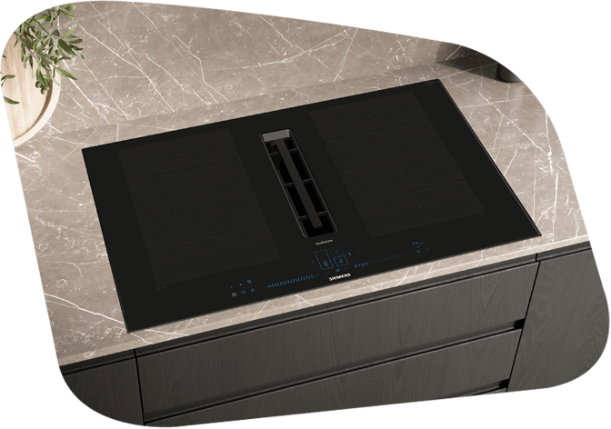 Schwarzes Induktionskochfeld mit integriertem Dunstabzug auf einer Marmorküchenzeile