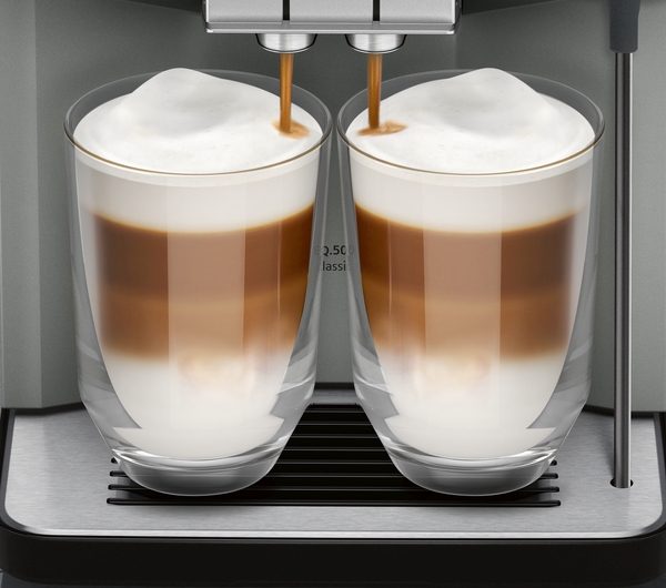 Zwei Gläser Latte Macchiato unter einem Kaffeevollautomaten