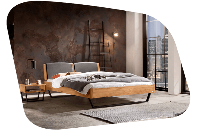 Holzbett mit Polsterkopfteil in einem Raum mit dunkler Metallwand