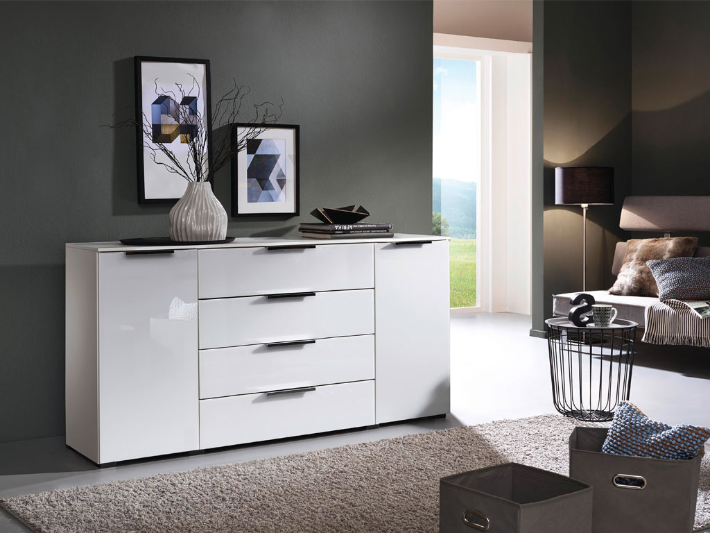 weiße Kommode mit zwei Türen und vier Schubladen mit schwarzen Griffen stillvoll dekoriert in einem modernen Zimmer