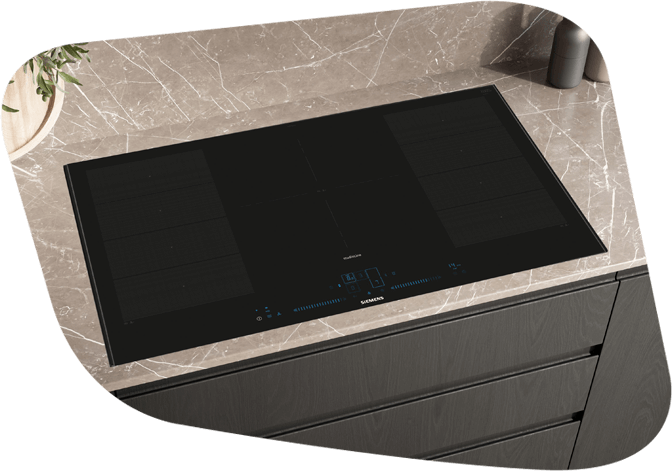 Ein eingebautes Induktionskochfeld auf einer Arbeitsplatte mit Marmormuster in einer modernen Küche.