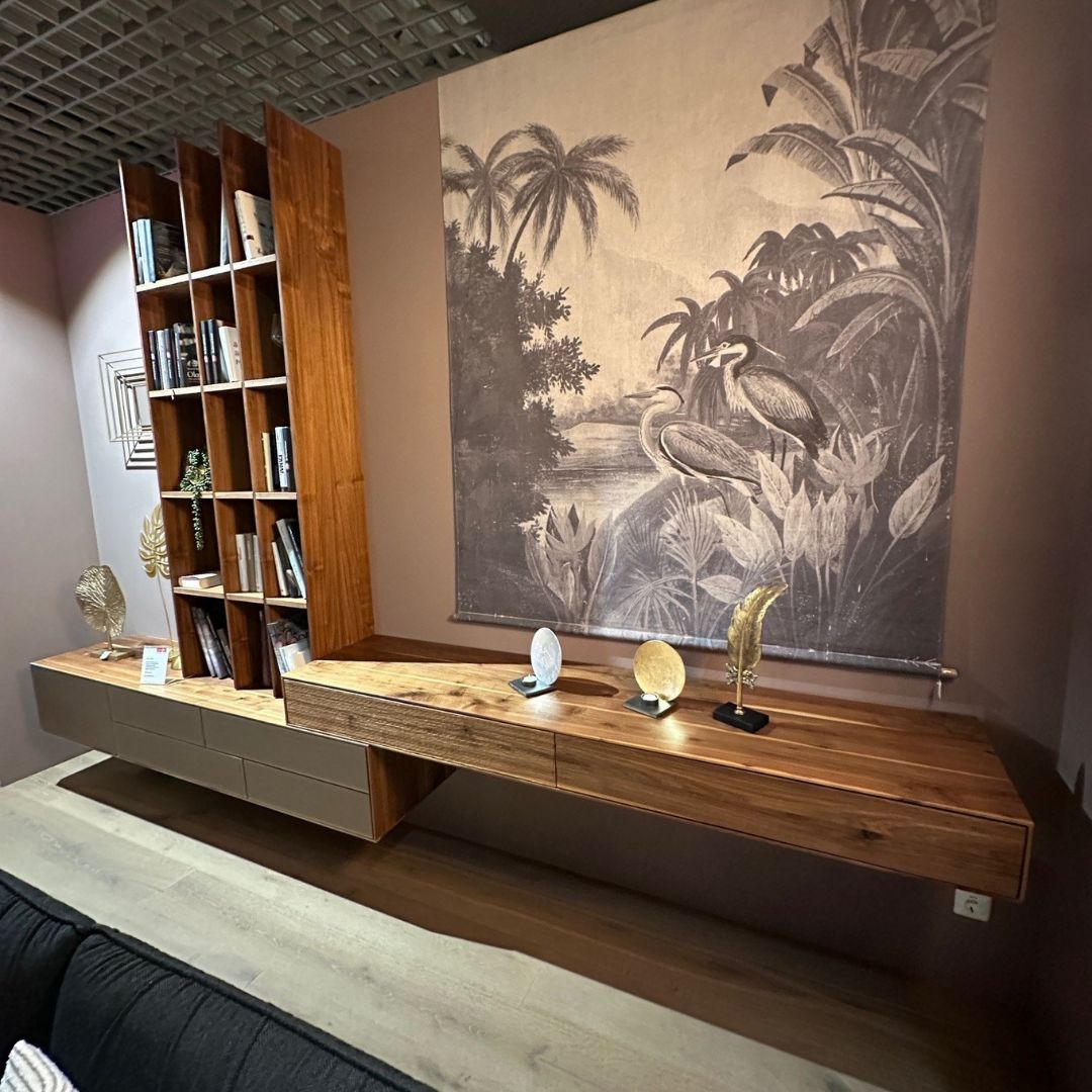 Anrei PURO | Wohnkombination Wohnzimmer mit hölzerner Bücherregal-Einheit, Wanddekoration mit Naturmotiv, und Dekoelementen auf Sideboard.