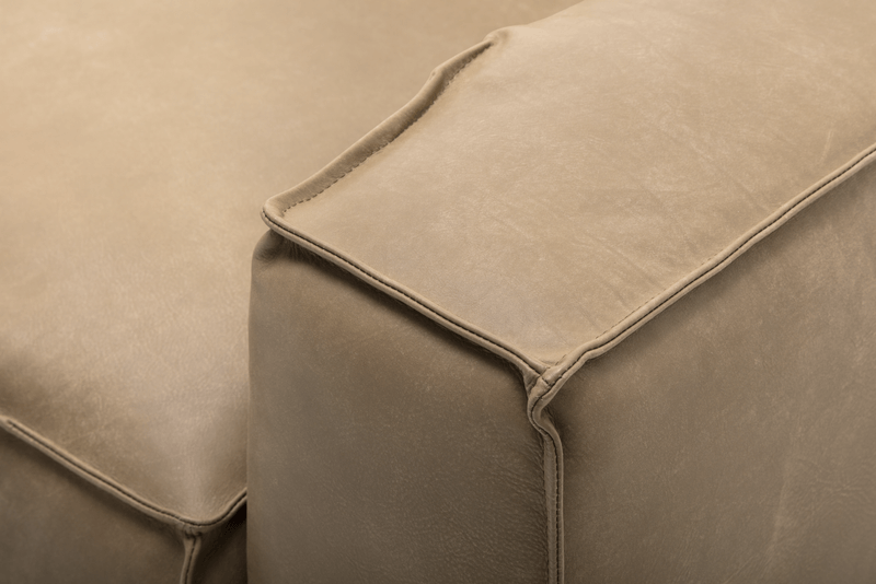 Nahaufnahme einer Ecke einer beigefarbenen Ledercouch mit sichtbaren Nähten