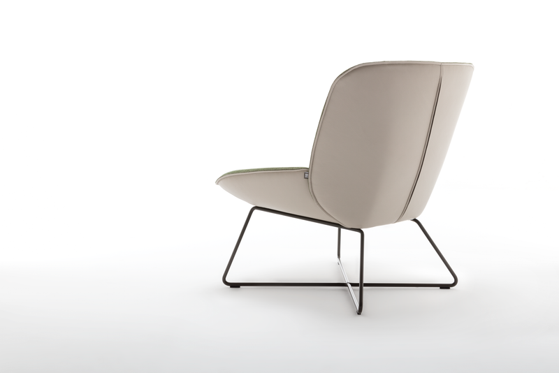 Seitenansicht eines modernen Polstersessels mit beigem Bezug und schwarzem Metallgestell