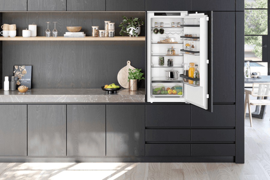 schwarze Küche mit Holzakzent und offen stehendem Kühlschrank