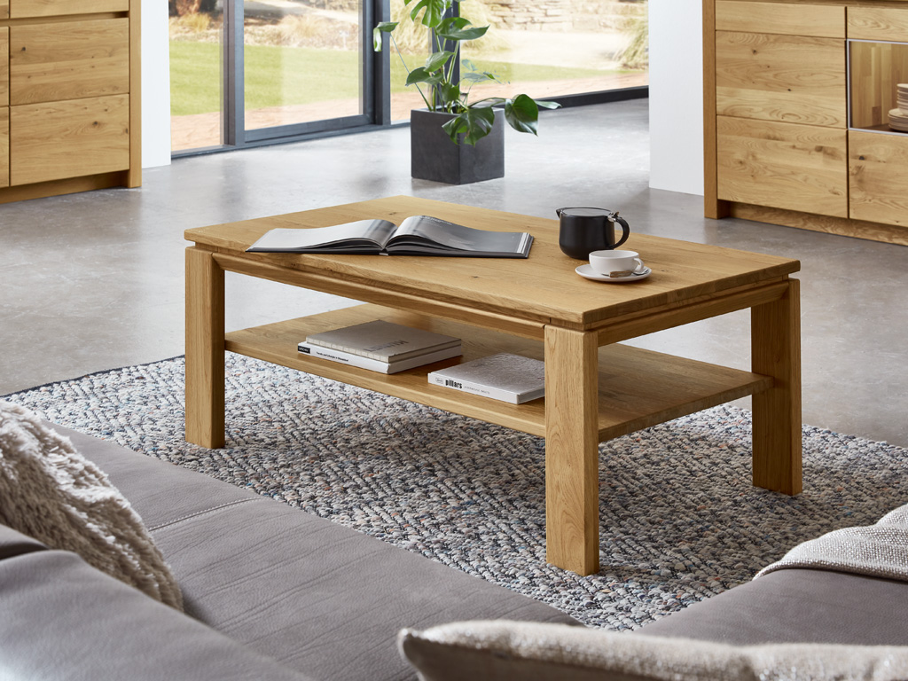 Wöstmann Soleo 3000 - Couchtisch | Type 9522/9507 | B: 120,0 cm | konfigurierbar Holz-Couchtisch im Wohnzimmer mit Büchern und Kaffeetasse darauf, umgeben von modernen Möbeln