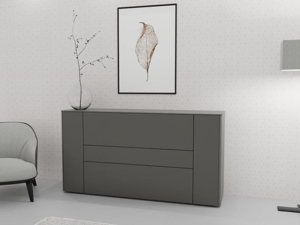 Sudbrock Goya - Sideboard | 2 Türen, 2 Schubladen, 1 Klappe | B: 175,2 cm | Lack onyxgrau Ein elegantes Wohnzimmer mit einer modernen grauen Kommode, dekoriert mit einem Glasvase und einem stilvollen Wandbild eines Blattes.