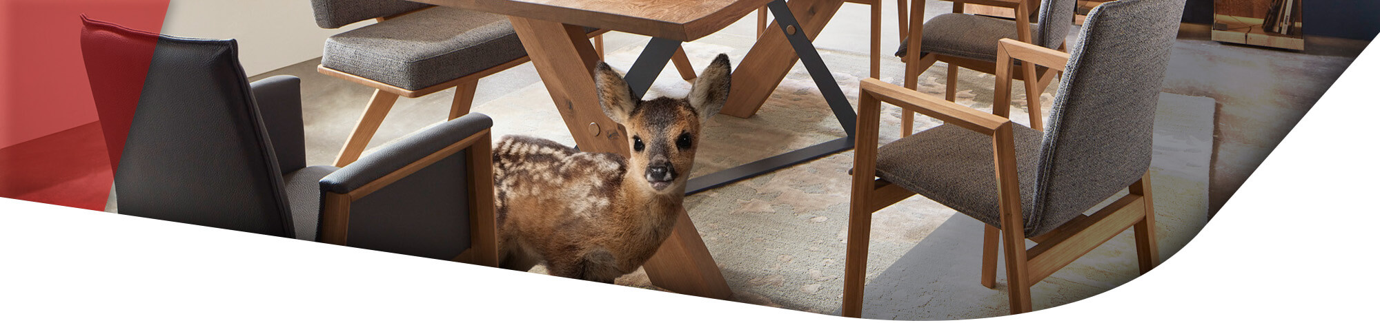 Rehkitz unter einem Massivholz Esstisch mit STühlen in hellgrauem Polster