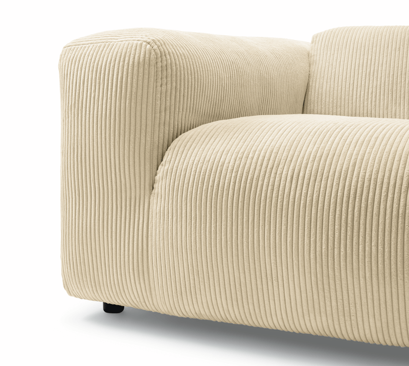 Detail eines modernen cremefarbenen Sofas mit weicher Rippstruktur und geradlinigem Design