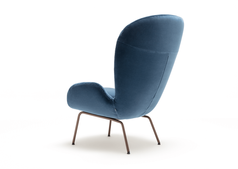 Rückansicht eines modernen blauen Sessels mit eleganten, schmalen Metallbeinen