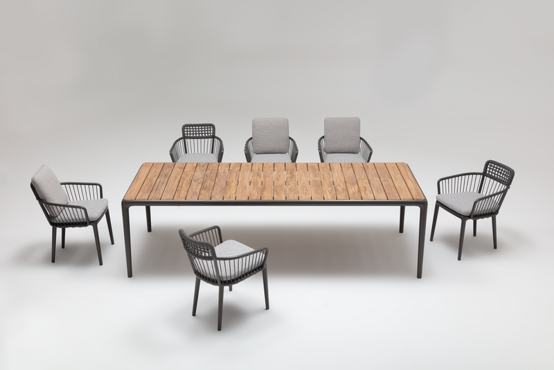 Ein moderner Esstisch aus Holz mit sechs grauen Stühlen, die ein stilvolles Design haben. Ideal für das Esszimmer oder die Terrasse.