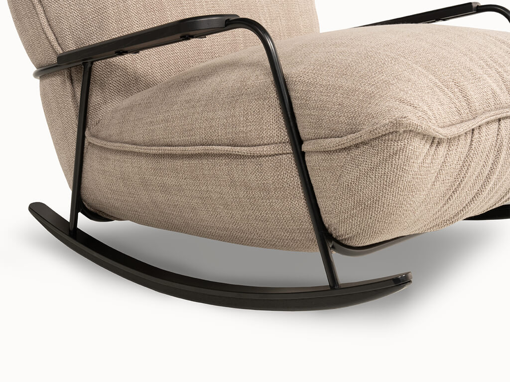 Detailansicht eines beige gepolsterten Schaukelstuhls mit schwarzem Metallrahmen