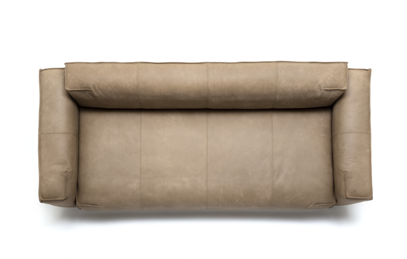 Bequemes beige Ledersofa mit modernen, breiten Armlehnen, von oben fotografiert