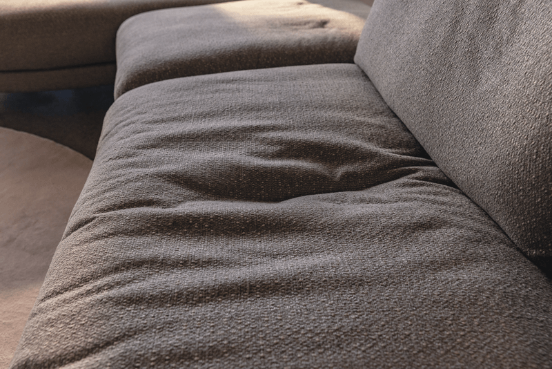 Stoffcouch mit sichtbarer Sitzmulde im Polster