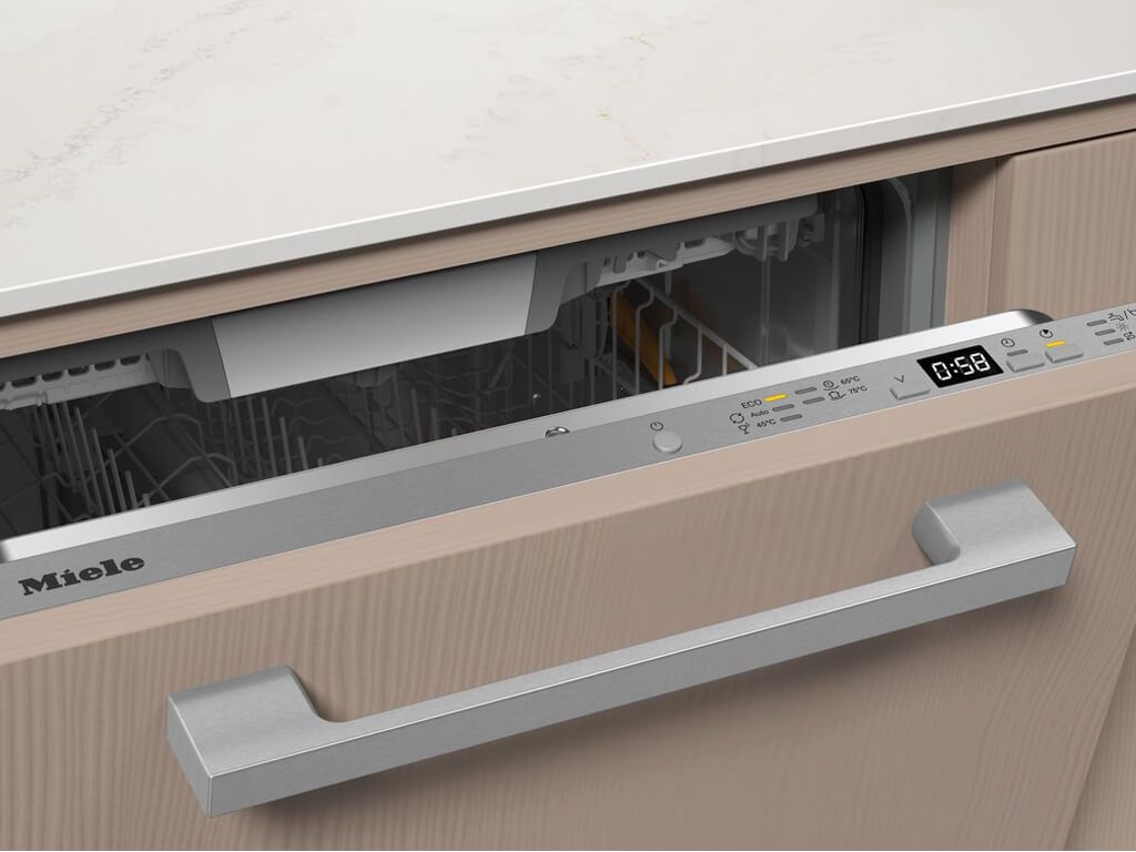 Nahaufnahme des oberen Bereichs eines geöffneten Miele Geschirrspülers, der in eine Küchenzeile mit heller Holzfront integriert ist.