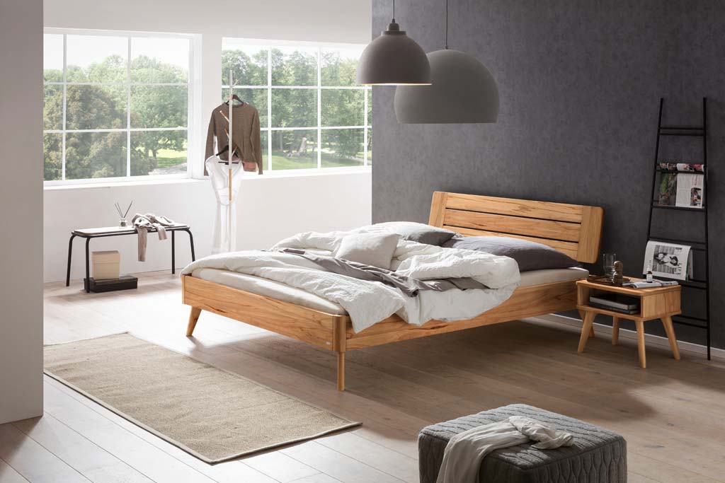 Holzbett mit Holznachttisch in einem stilvoll eingerichten Zimmer