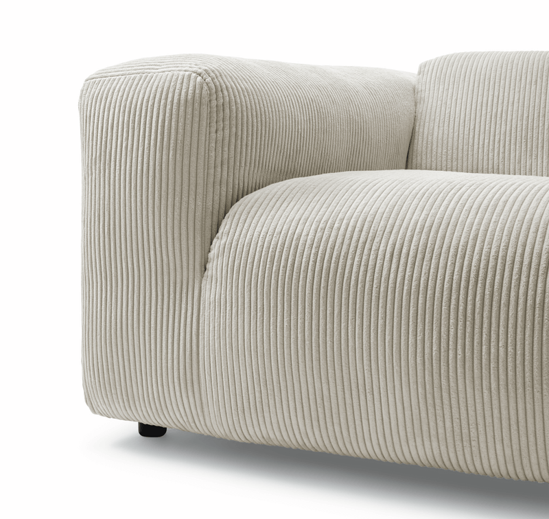 Nahaufnahme eines modernen cremefarbenen Sofas mit weichem Rippenmusterbezug