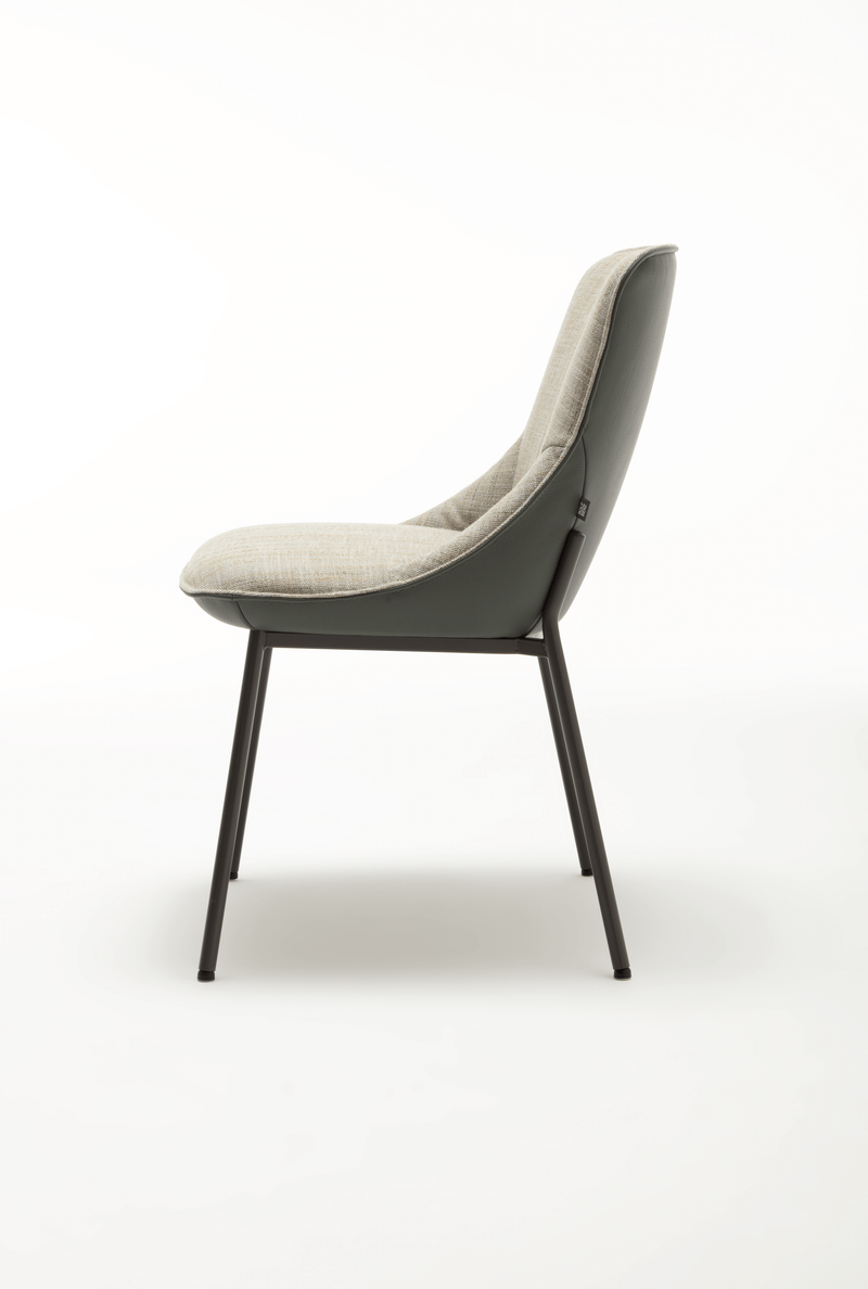 Seitenansicht eines modernen Stuhls mit grauem Stoffbezug und Metallbeinen, auf weißem Hintergrund