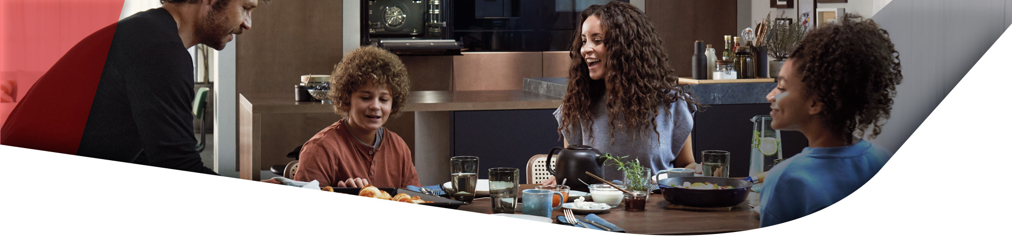 Familie am Esstisch vor der Küche