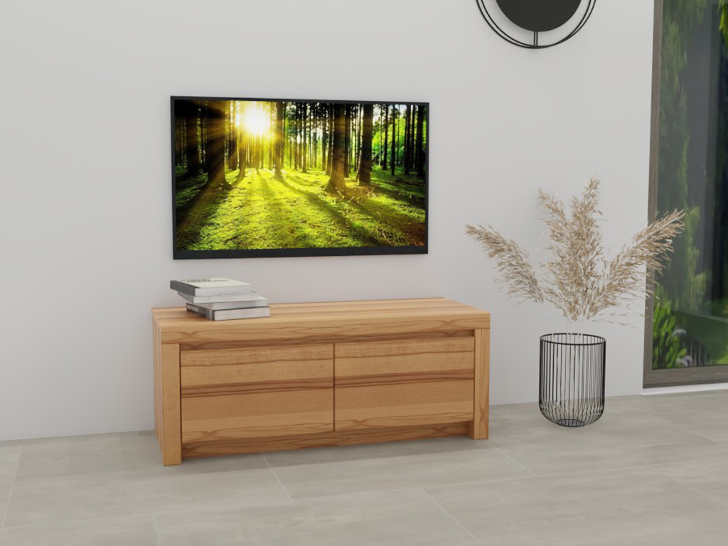 Wöstmann Soleo 3000 - Lowboard | Type 1352 | B: 131,2 cm Ein minimalistisches Wohnzimmer mit einer Holzkommode, darauf Bücher gestapelt. An der Wand hängt ein Bild eines sonnendurchfluteten Waldes. Daneben steht eine Vase mit Trockenblumen.