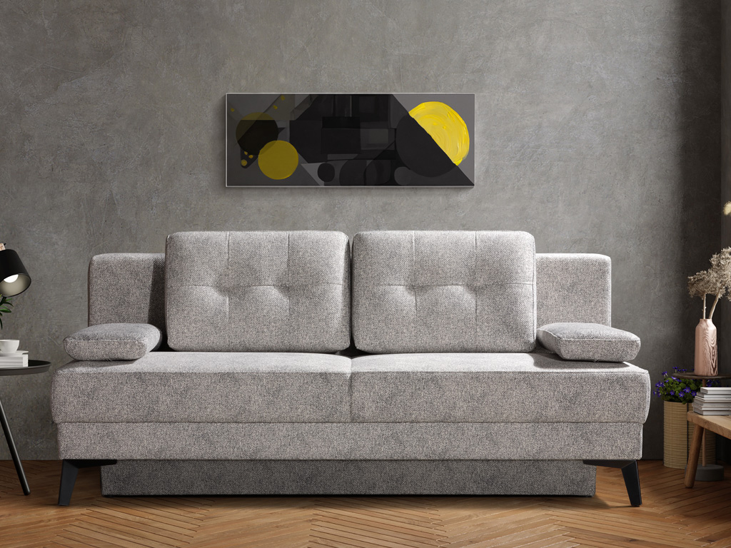 Restyl Fanny - Schlafsofa (Querschläfer) | hellgrau | mit Bettkasten | 155 x 200 cm Graues Sofa vor einer Wand mit abstraktem Kunstwerk, umgeben von Lampe und Pflanzen