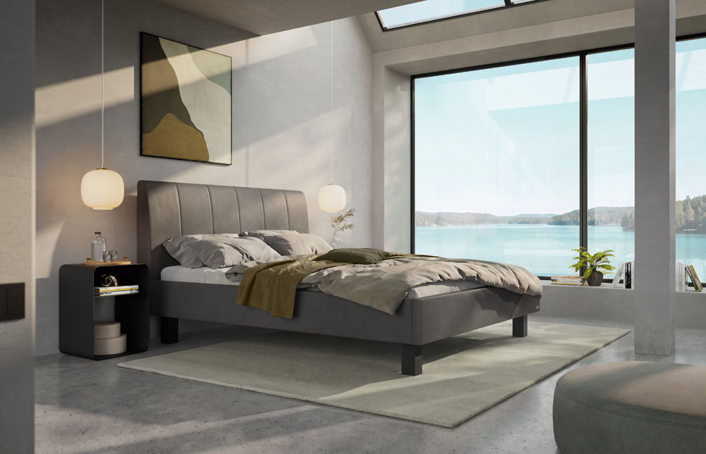 Graues Polsterbett mit vertikal gestepptem Kopfteil und schwarzen Füßen in einem modernen Loft-Schlafzimmer mit großem Panoramafenster und Seeblick (KI-generiert)