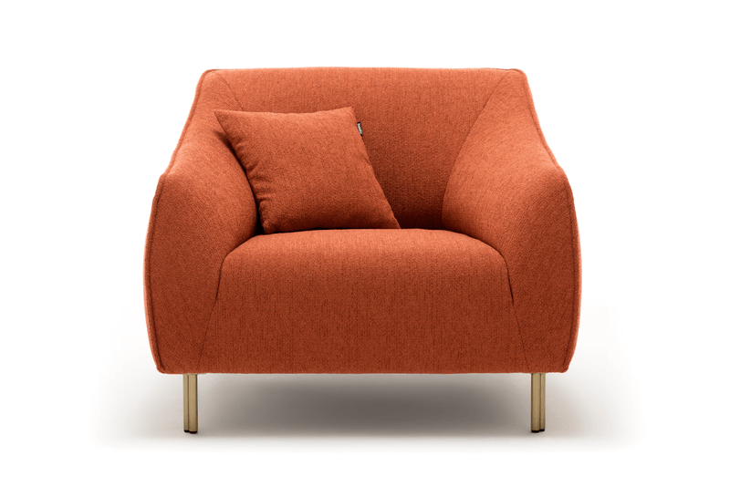 Gemütlicher, terrakottafarbener Sessel mit passendem Kissen vor weißem Hintergrund