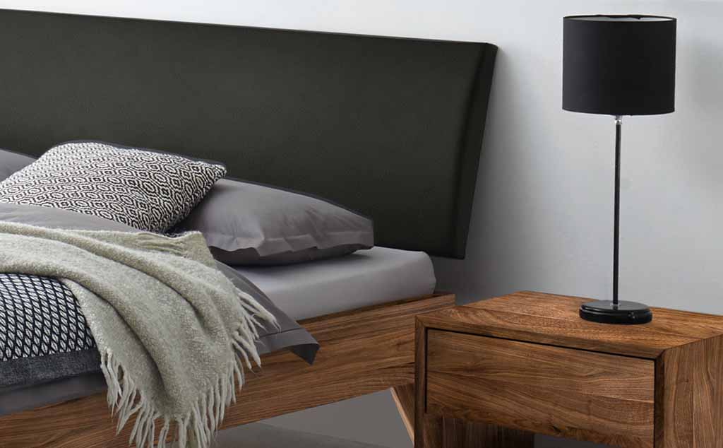 Gemütliches Schlafzimmer mit Holzbett, Nachttisch und Stehlampe