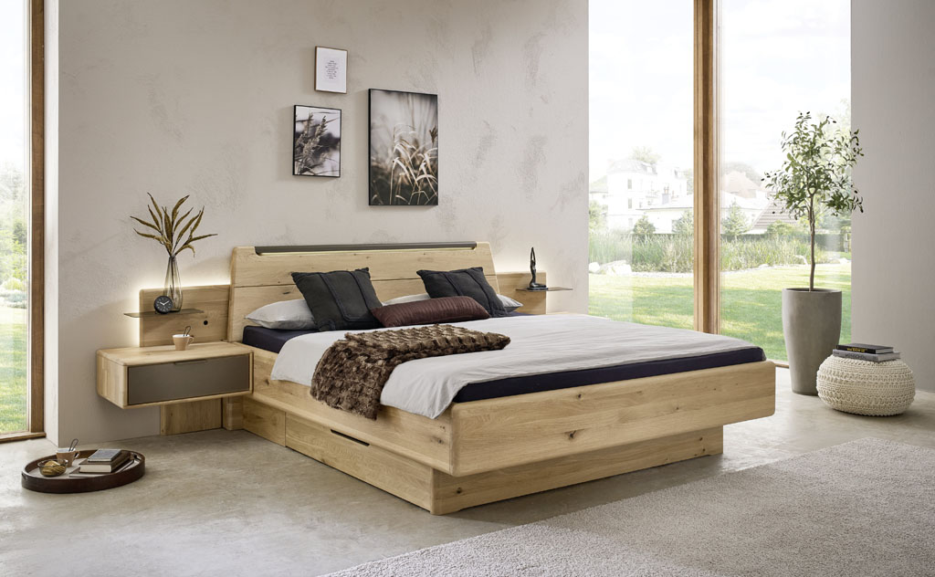 modernes Holzbett mit zwei Hängekonsolen mit Beleuchtung stilvoll dekoriert in einem modernen Raum