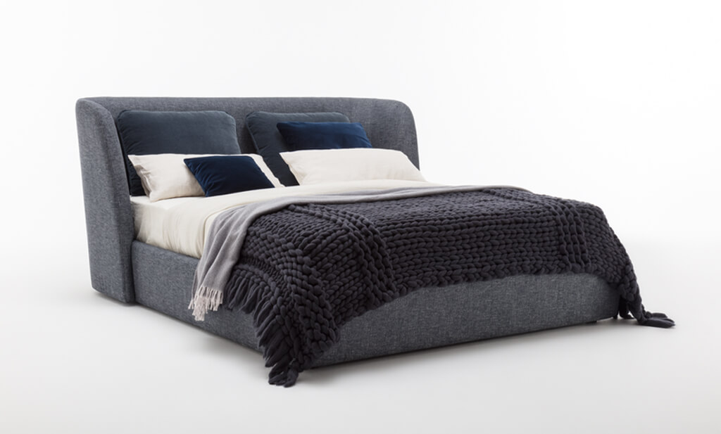 blau/graues Polsterbett mit großmaschig gestrickter Tagesdecke