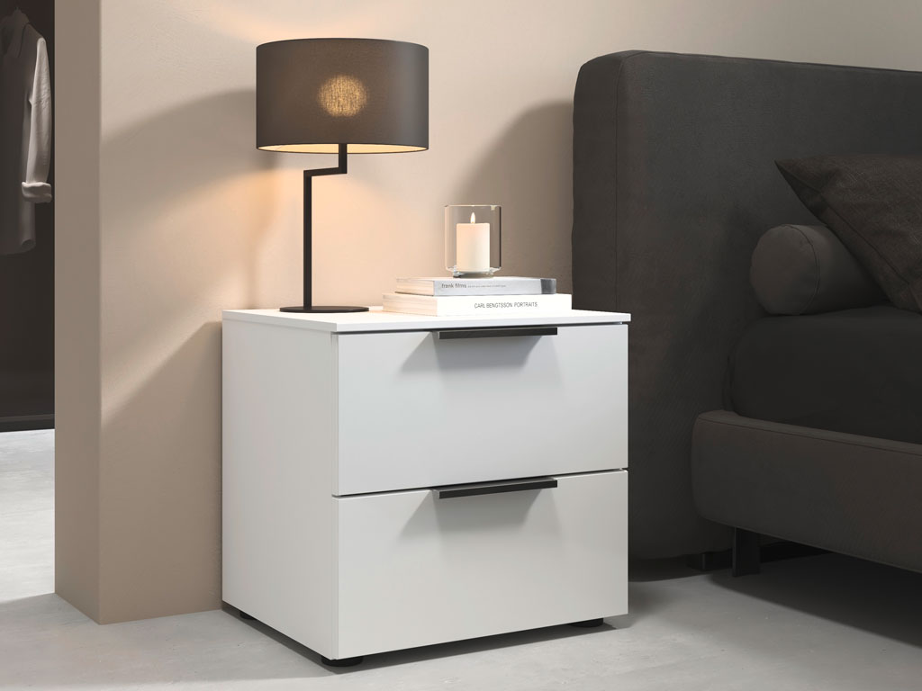 weißer nachttisch mit zwei schubkästen platziert neben einem bett in einem modernen zimmer stilvoll dekoriert