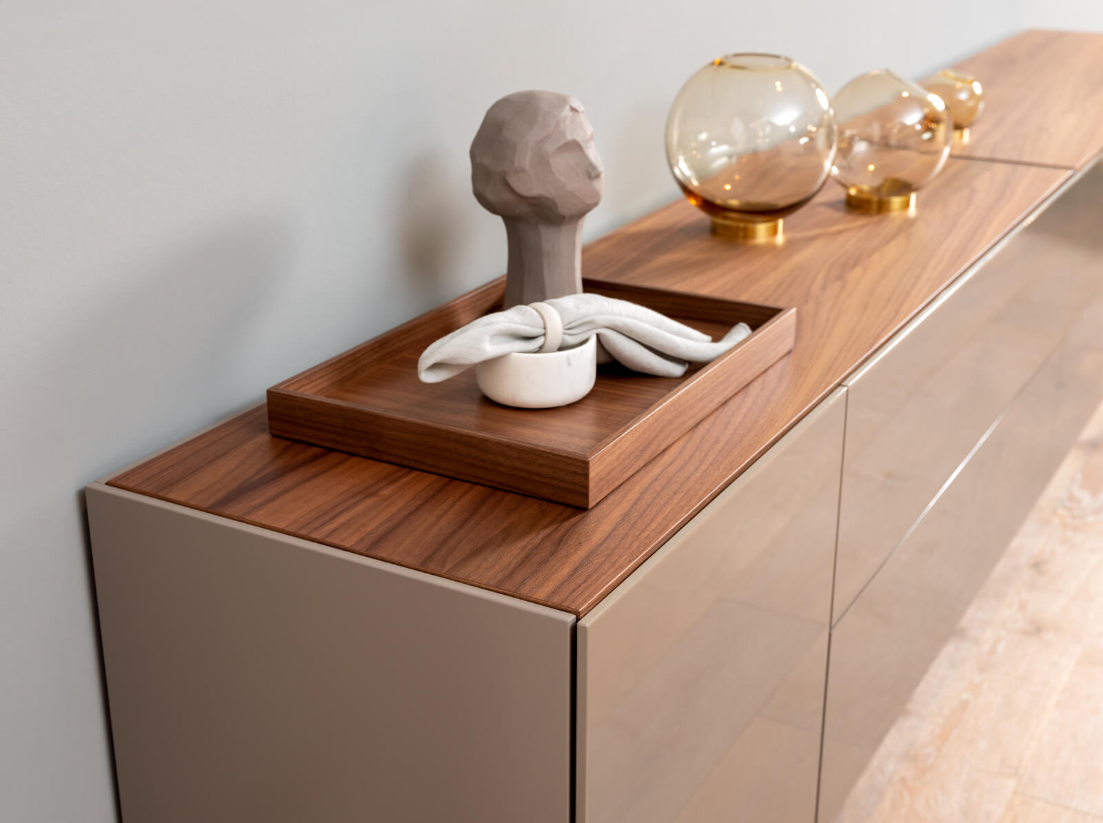 Holzkommode mit Schale, Skulptur und Glasdekorationen