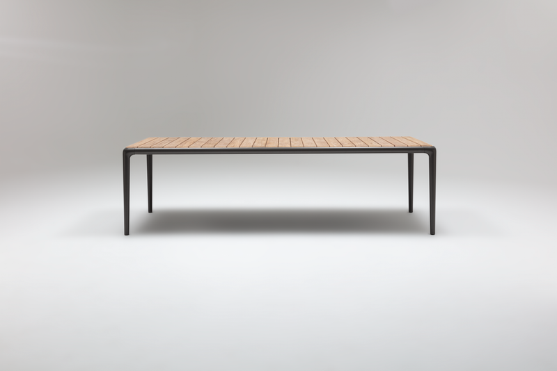 Schlichter, langer Esstisch mit hölzerner Tischplatte und schwarzen Metallbeinen in minimalistischer Ausführung.