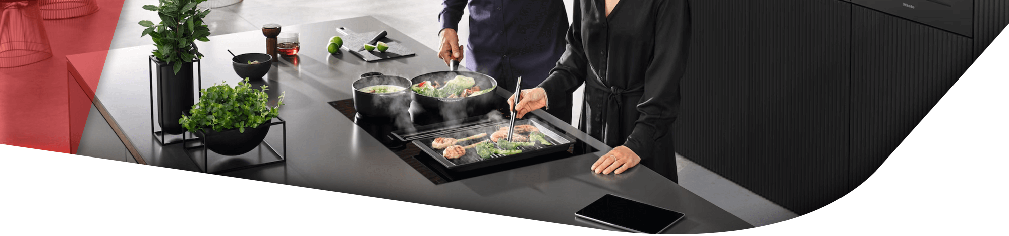 zwei Personen stehen am Herd und Kochen gemeinsam auf dem Induktionskochfeld mit Grillplatte & Töpfen