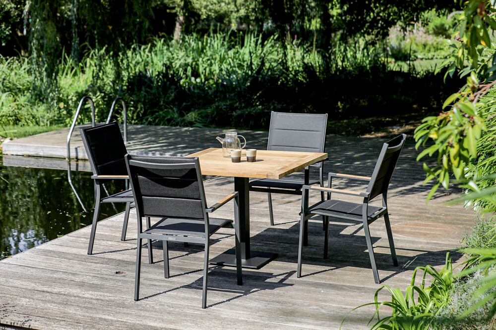 Kleiner Tisch mit vier Gartenstühlen auf Terrasse