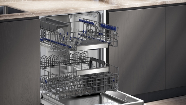Offene Geschirrspülmaschine mit herausziehbaren Körben in einer modernen Kücheneinrichtung