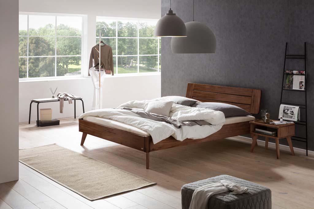 Holzbett mit Holznachttisch in einem stilvoll eingerichten Zimmer