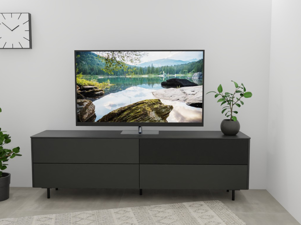 Sudbrock Goya - Lowboard mit Lochblechklappe | 2 Schubladen, 2 Klappen | B: 205,2 cm | Lack quarz Ein stilvoller Raum mit einem modernen Fernseher auf einem dunklen Schrank, dekoriert mit einer Pflanze und einer Wand-Uhr.