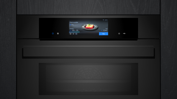 Nahaufnahme der oberen Frontpartie des schwarzen Backofens mit Fokus auf das leuchtende TFT-Touchdisplay und die minimalistische Bedienoberfläche.