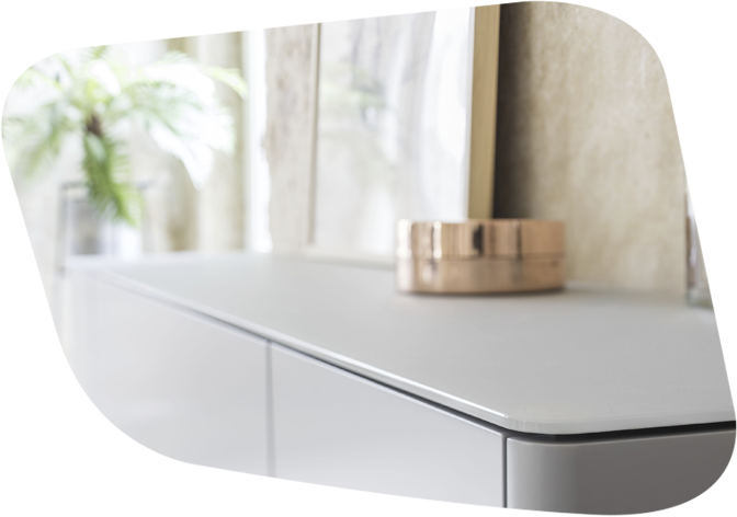 Ein modernes Sideboard in einem stilvoll eingerichteten Wohnzimmer. Dekoriert mit einem goldfarbenen Objekt und gerahmten Bildern.