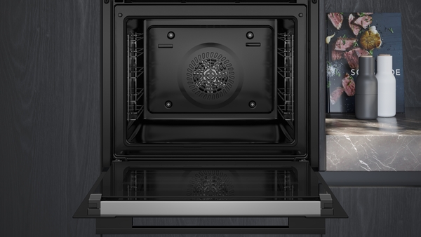 Detailansicht eines modernen Einbau-Backofens mit geöffneter Tür in einer eleganten, dunklen Küche.