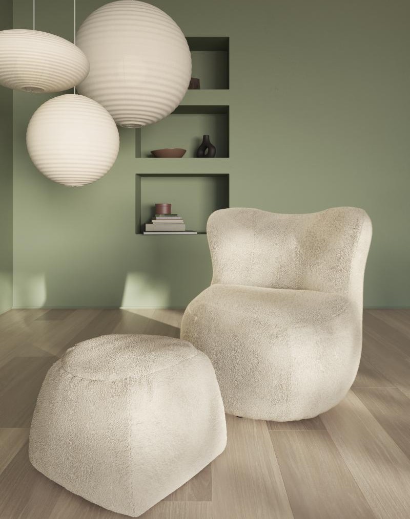 designersessl mit pouf in beige stilvoll dekoriert in einem modernen raum mit drei großen runden ballförmigen deckenleuchten