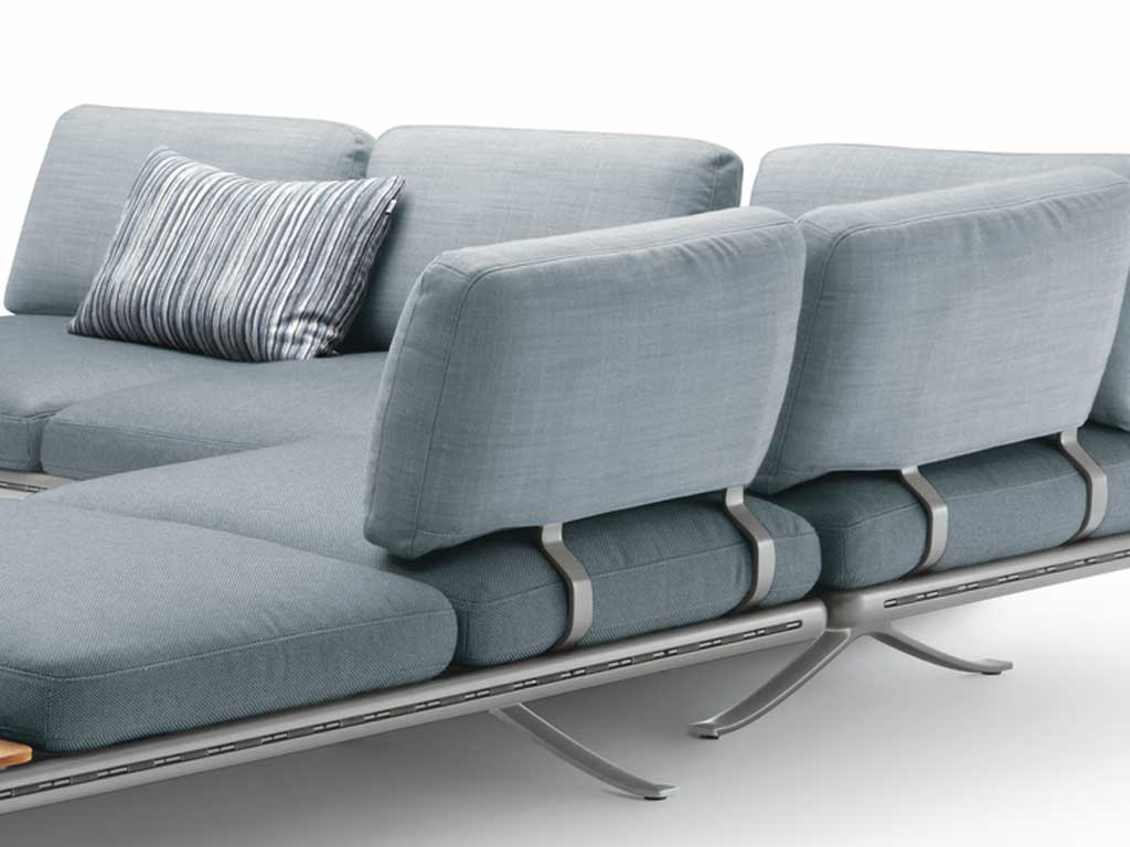 Rolf Benz Yoko 219 - Seitenteil- und Rückenbügel Nahaufnahme eines modernen grauen Sofas mit metallenen Details und einem gestreiften Kissen