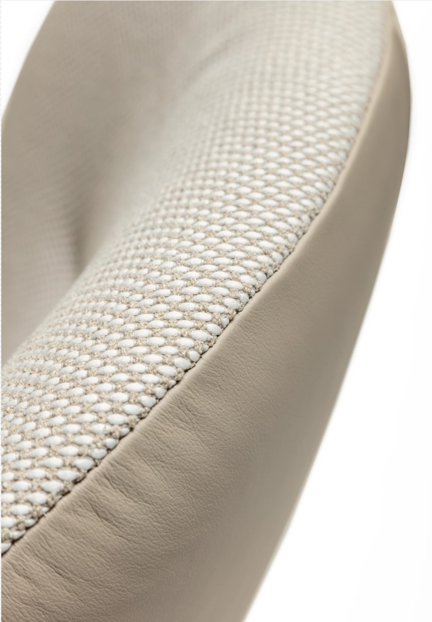 Detailaufnahme eines Designersessel zweifarbig beige vor weißem Hintergrund