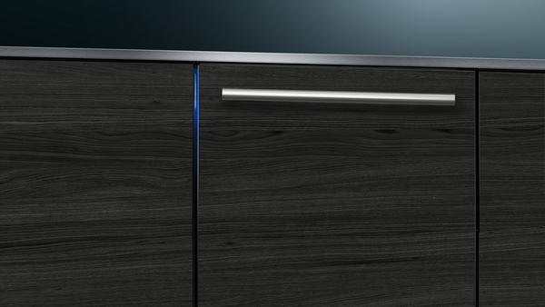 Detailaufnahme eines modernen Küchenschranks in dunkler Holzoptik mit silbernem Edelstahlgriff